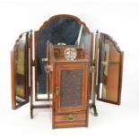 An Edwardian oak smokers cabinet, the door opening to reveal two drawers with brass handles, the
