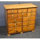 An antique pine chest of drawers comprising six short over four medium and two deep drawers with