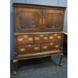 A Georgian oak cabinet on chest raised on stand, the cabinet having two panelled doors enclosing a