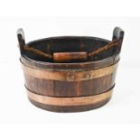 A 19th century oak coopered barrel form basket, with metal liner, and rope and treen carrying