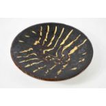 A terracotta slipware bowl, with treacle coloured glaze and impressed edge, 31cm diameter.