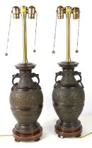 A pair of Chinese bronze table lamps, 20th century, cast with decoration to depict dragons, turtles,