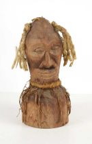 An African tribal carved wooden face mask ornament, the head having strands of wool for hair, 23cm