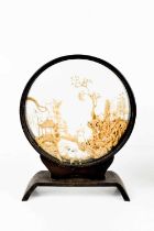 A Chinese antique cork display, the glazed circular stand housing the intricately carved cork