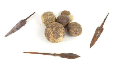 A group of cast iron cannonballs together with a Persian bronze spearhead, Syrian 2nd century iron