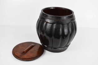 A Chinese Qing Dynasty wooden rice jar and cover, of lobed form, black lacquered to depict a house