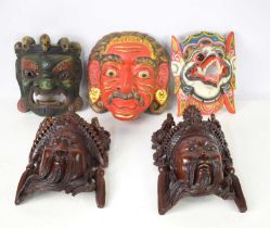 A group of Bhutanese, Balinese and Chinese wooden carved wall masks to include Mahakala, a Chinese