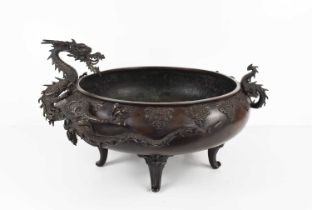 A Chinese bronze censor, circa 1900, modelled with a wrythen dragon clutching the sides of the