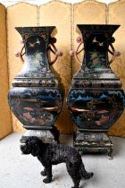 A large and impressive pair of 19th century papier mache black lacquered vases, raised on wooden