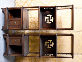 A pair of Chinese hardwood cabinets, the four tiers having a panel back pierced with Buddhist