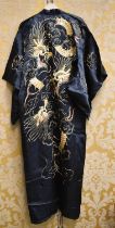 A 1920's/1930's black silk robe, of loose form, embroidered in gold and coloured silk threads with a