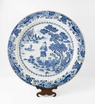 An early 19th century Chinese blue and white charger, depicting a figure standing beside a tree with