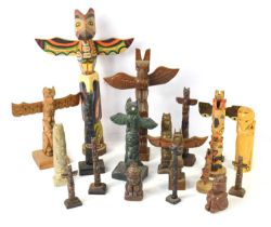 A group of Native American totem poles, to include carved wooden and composite examples.