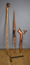 A vintage Native American decorative wooden bow together with a carved wooden staff and two tomahawk