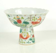 A Chinese porcelain stem cup, the body decorated with fish / carp and plants, the base bearing a six