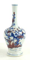 A Chinese bottle vase, in blue, red and white, depicting a bird perched in a prunus blossom tree,