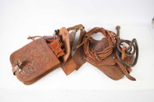 A pair of leather saddle bags for horses, the bags decorated with floral motifs, the bags containing