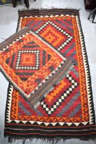 Two early 20th century Middle eastern kilim rugs, with red, orange, black and white geometric