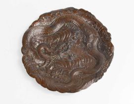 A Chinese bronzed dish, embossed with a wrythern dragon, 18cm diameter.