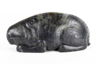 A Qing Dynasty black jade mythical beast, of large pebble form, shown crouched with the legs
