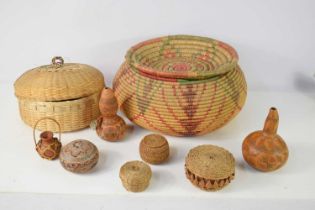 An African bot belly woven basket together with various decorated calabash gourds and other items.