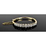 A stunning and impressive diamond and 18ct gold bangle, set with eleven brilliant oval cut diamonds,