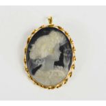 An 18ct gold and cameo pendant brooch, the black and cream shell carved to reveal a young woman