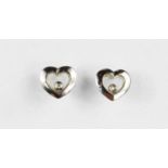 A pair of 9ct white gold heart shaped earrings with floating white stone, likely diamond, with screw