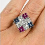 An 18ct white gold diamond, sapphire and ruby cluster ring, having a central diamond double lined '