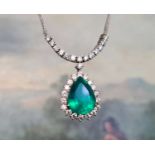 An 18ct white gold, emerald and diamond pendant necklace, the pendant of pear cut split emeralds