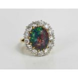 An 18ct hallmarked opal and diamond cluster ring, central oval opal, length 13mm, within a border of