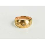 A 9ct gold ring, illusion set with three diamond brilliants in starburst engraved setting and