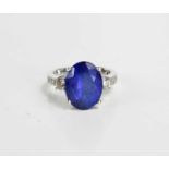 An 18ct white gold tanzanite and diamond dress ring, the central oval cut tanzanite of 13.4 by 10.