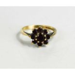 A 9ct gold and garnet flowerhead ring, set with central round cut garnet, surrounded by eight