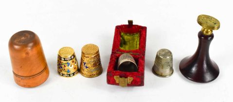 A group of thimbles, to include enamel and gilt metal examples, silver plated example with