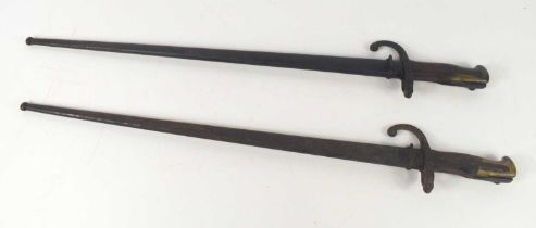 Two French model 1874 bayonets, one marked St Etienne and dated 1876, both with scabbards.