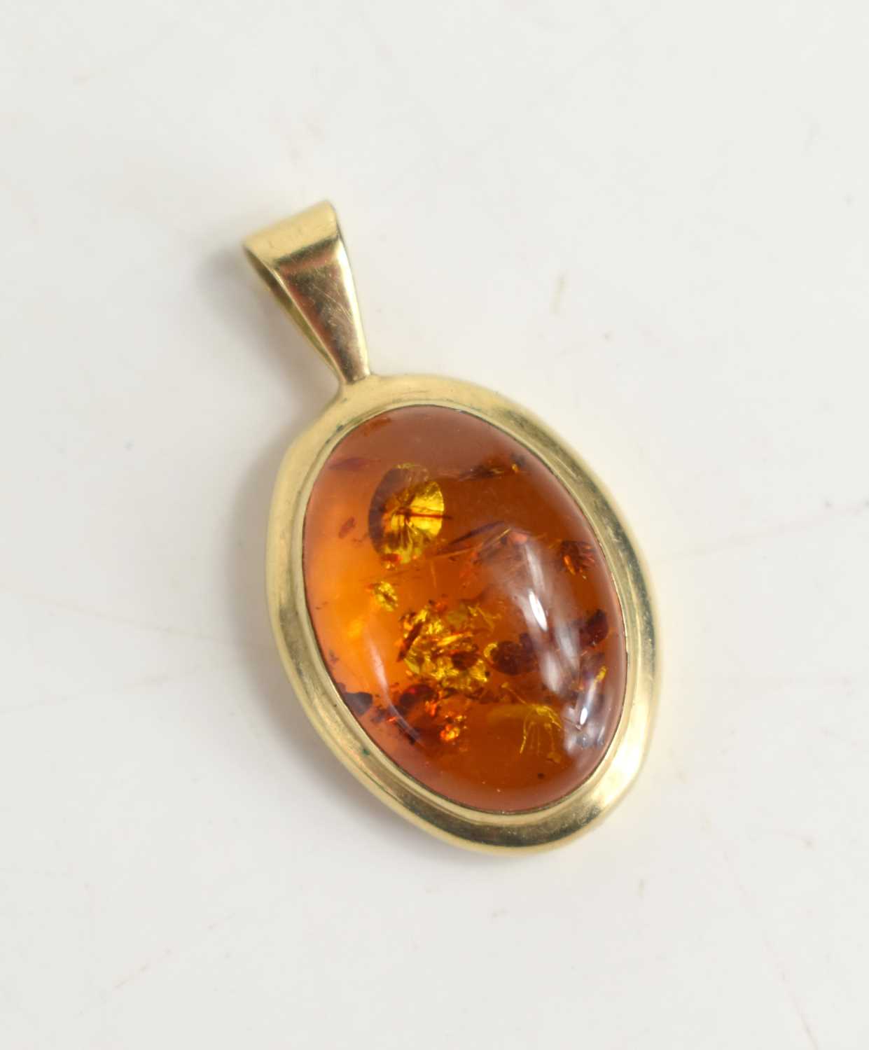 A 9ct gold set amber pendant, the oval amber cabochon of approximately 1.5 by 1cm, total weight 2.