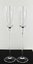 A pair of tall crystal champagne flutes, the elegant long tapering stems 24cm high.