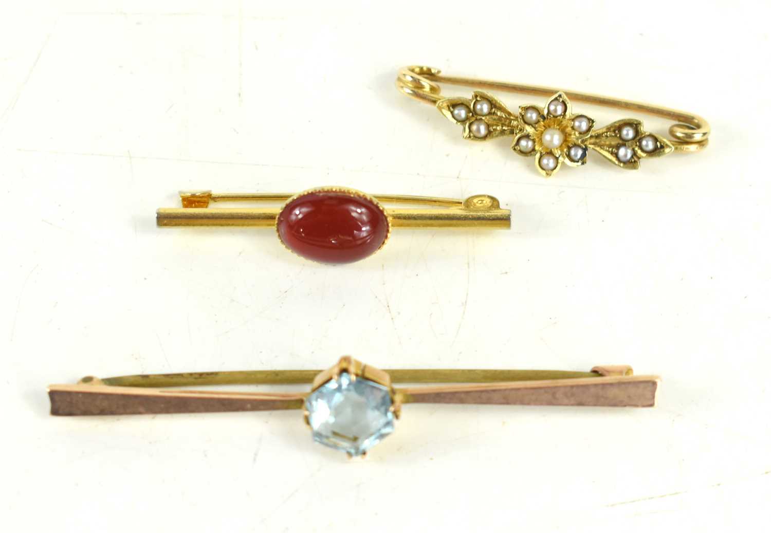 A 9ct gold and aquamarine bar brooch, with base metal pin, 2.86g, together with two further small