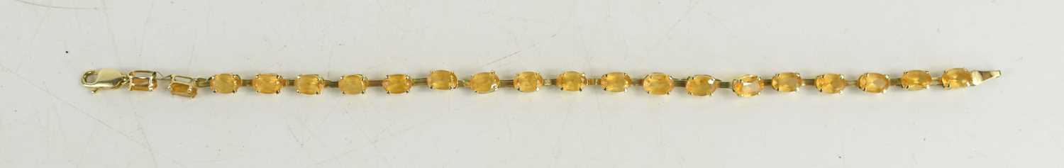 A 9ct gold and citrine bracelet, set with twenty oval cut citrines, 19cm long, 4.43g. [This lot