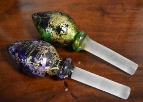 Two hand blown glass bottle stoppers, one in green and the other purple, with gilded overlay.