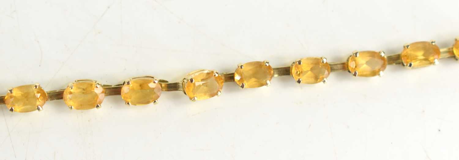 A 9ct gold and citrine bracelet, set with twenty oval cut citrines, 19cm long, 4.43g. [This lot - Image 2 of 2