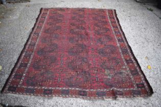 A Middle Eastern red ground rug, with stylised geometric borders.