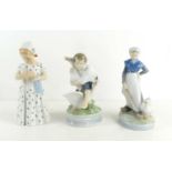 A group of three Royal Copenhagen figurines to include a young girl holding a doll, number 561, a