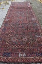 A large woollen hallway runner / rug, reg ground with stylised patterns, 189cm by 522cm.