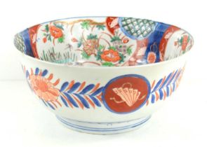 An antique Japanese bowl in the Imari pattern, decorated with flowers and foliage, 25cm diameter.