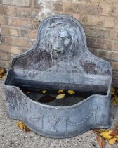 A lead bow fronted water fountain, the arched back with lion mask decoration.