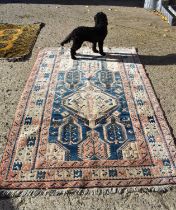 A Middle Eastern wool rug carpet, with soft pink and blue hues, 220 by 140cm.