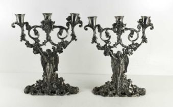 A pair of pewter Art Nouveau style table candelabra, each with three candle sockets raised by female