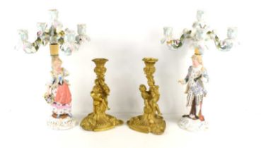 A pair of French style gilt metal candlesticks with cherubs modelled to the centre together with a